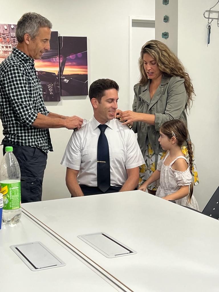 Elad's family pinning his captain's epaulettes